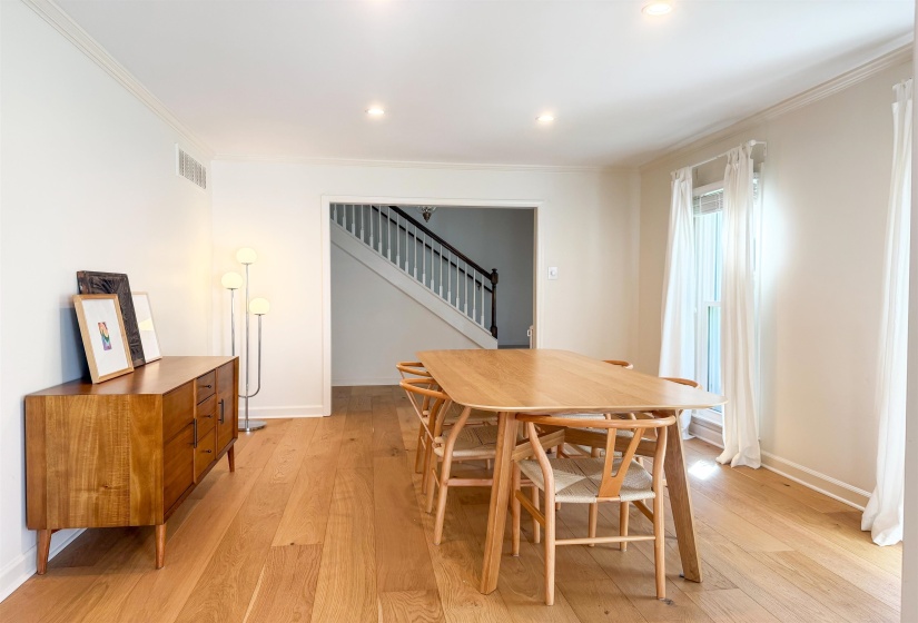 Hardwood flooring extends throughout this room, featuring recessed lighting and crown molding