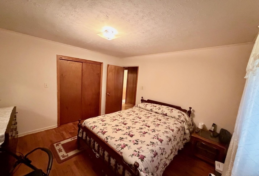 Bedroom featuring wood-finish flooring, a double-door closet, and an additional interior doorway