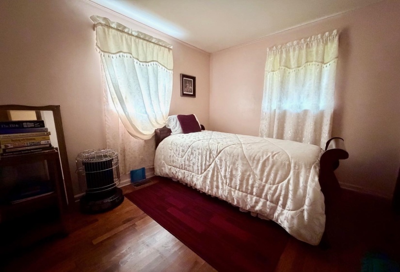 Hardwood flooring extends throughout this room, featuring a white ceiling and light-toned walls