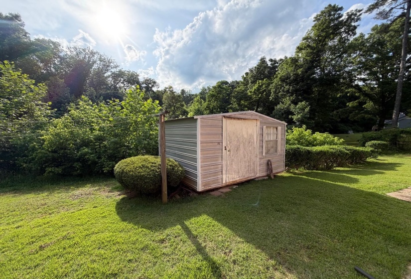 Outdoor storage shed with mixed material siding, featuring a window and double doors