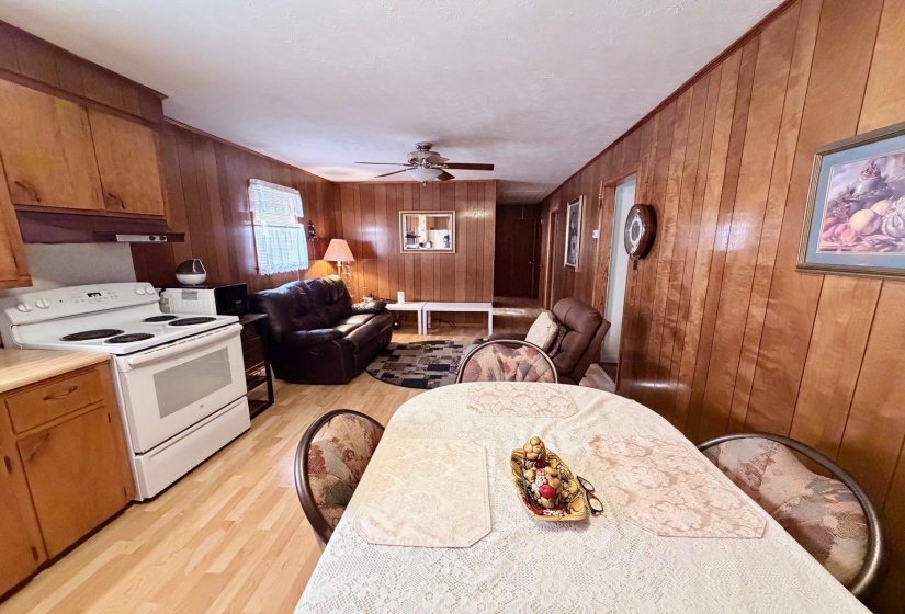 Kitchen and living area featuring wood-finish flooring and paneled walls