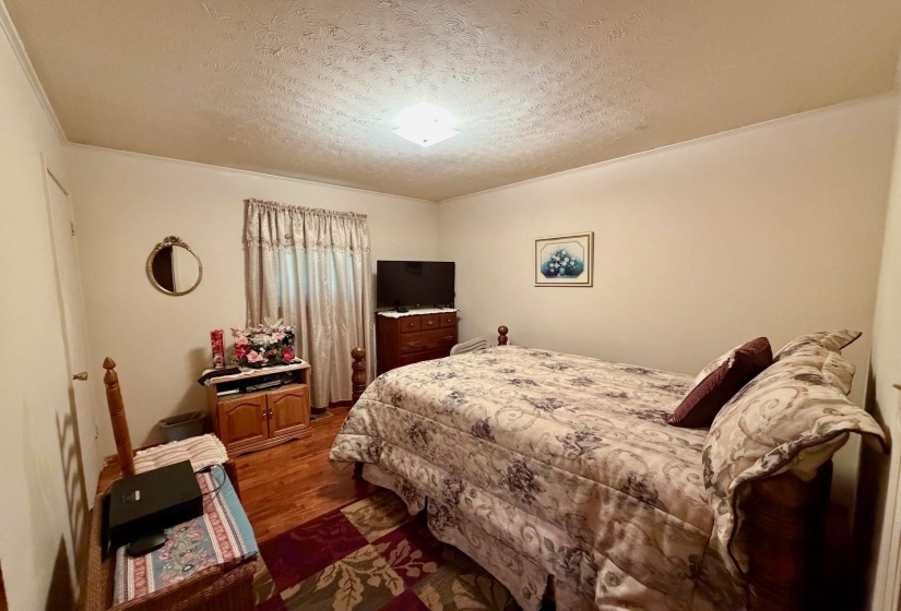 Bedroom featuring wood-finish flooring, a neutral wall color, and a ceiling light fixture
