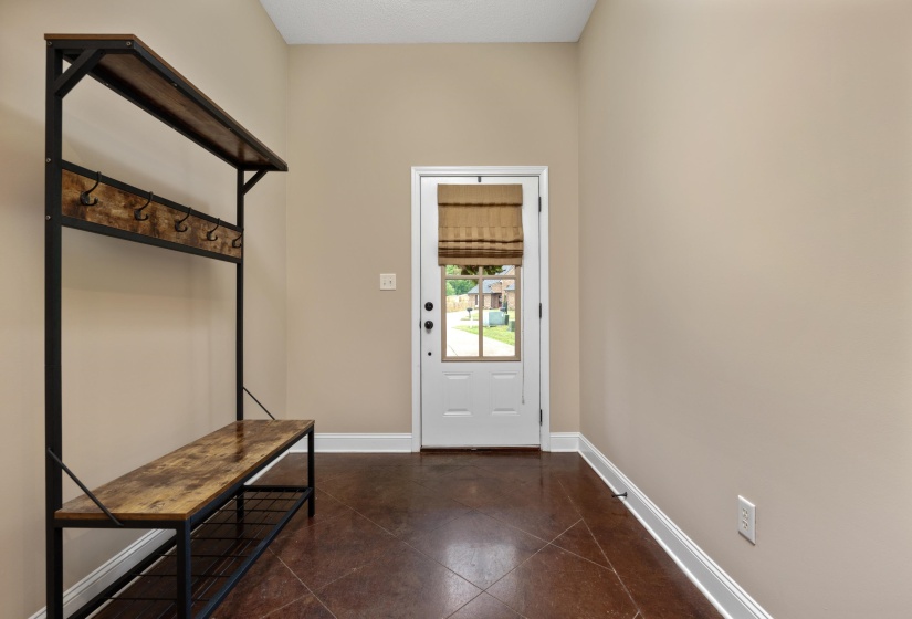 Entryway mudroom featuring a built-in storage bench with coat hooks and overhead shelf