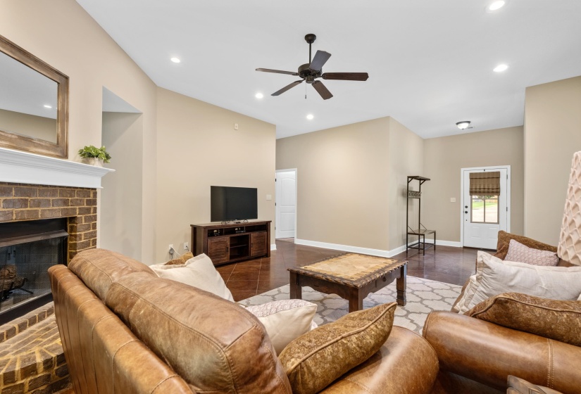 Spacious living area featuring a brick fireplace with a white mantel, recessed lighting, a ceiling fan, and wood-finish flooring