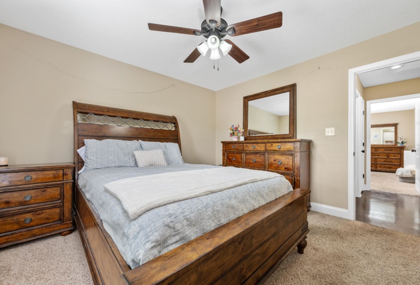 Carpeted bedroom with a ceiling fan light fixture and neutral wall color