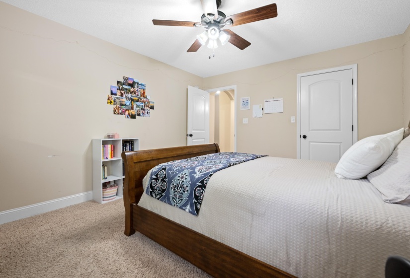 Carpeted room featuring a ceiling fan with integrated lighting, a white interior door, and neutral wall tones