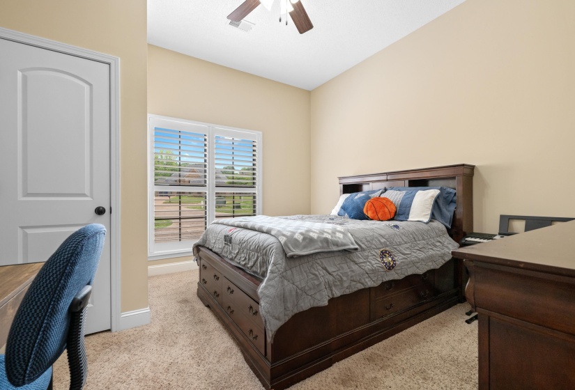 Carpeted room featuring a double window with white blinds, neutral painted walls, and a ceiling fan with light fixture