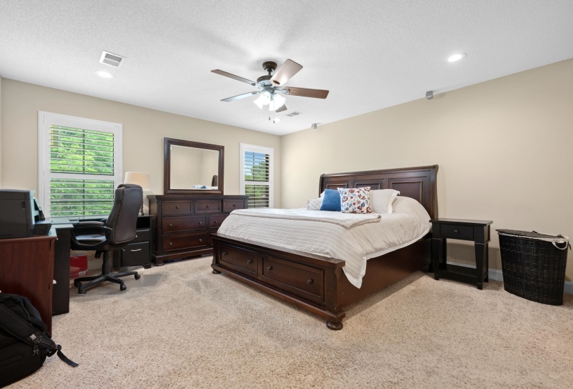 Carpeted room featuring two windows with white blinds, recessed lighting, and a ceiling fan