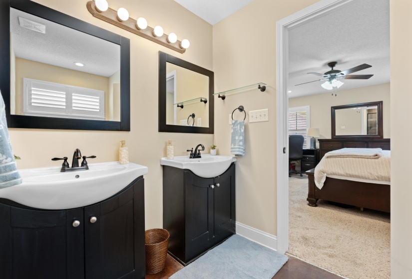 Bathroom featuring dual black vanities with integrated white sinks, matte black faucets, and individual framed mirrors