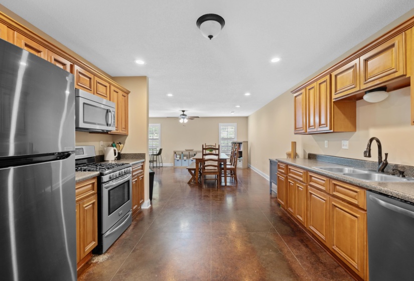 Kitchen featuring wood cabinetry, stainless steel appliances including a gas range and microwave, and recessed lighting