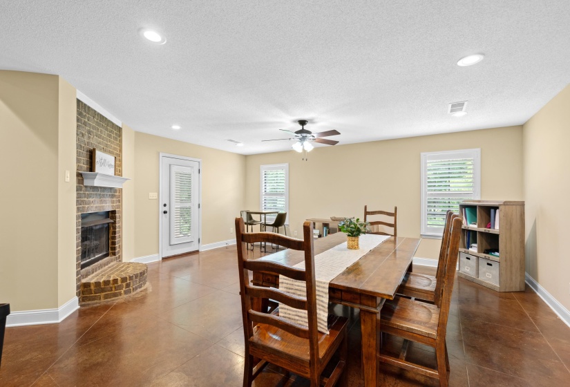 Spacious room featuring a brick fireplace with a white mantel, recessed lighting, and wood-finish flooring