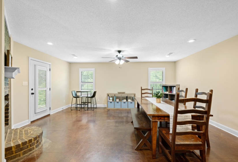 Spacious room featuring rich, stained concrete flooring, recessed lighting, and a ceiling fan