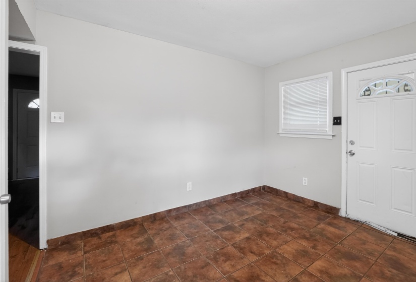 Neutral tone wall paint with a window and white blinds, complemented by a white paneled door with an arched glass insert