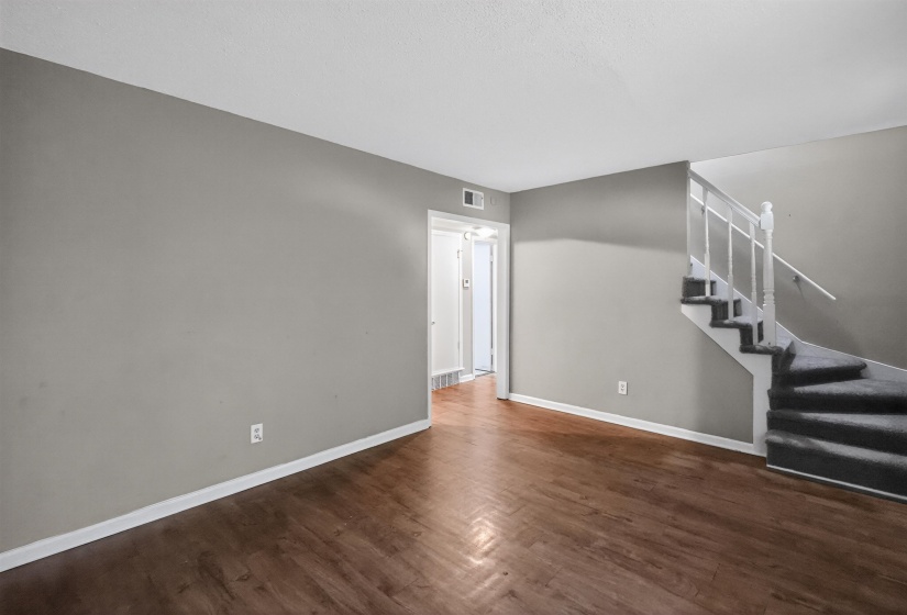 Interior space featuring wood-finish flooring, light gray wall paint, and white baseboards