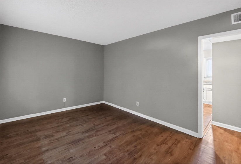Open concept room featuring wood-finish flooring, light gray wall paint, and white baseboards