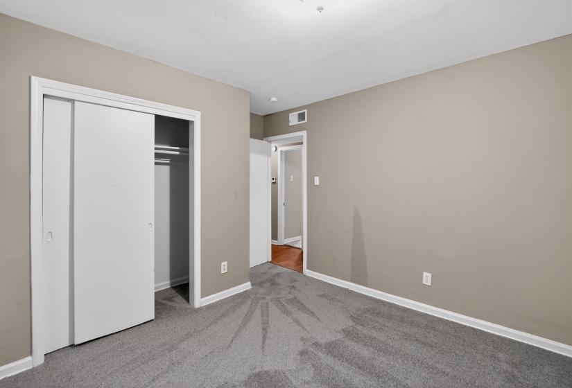 Bedroom with neutral wall paint and grey carpeting