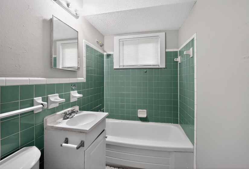Bathroom featuring a white vanity with an integrated sink and chrome fixtures