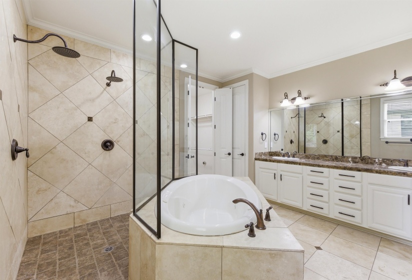 Spacious bathroom featuring a built-in soaking tub, walk-in shower with dual showerheads, and a double vanity with ample storage