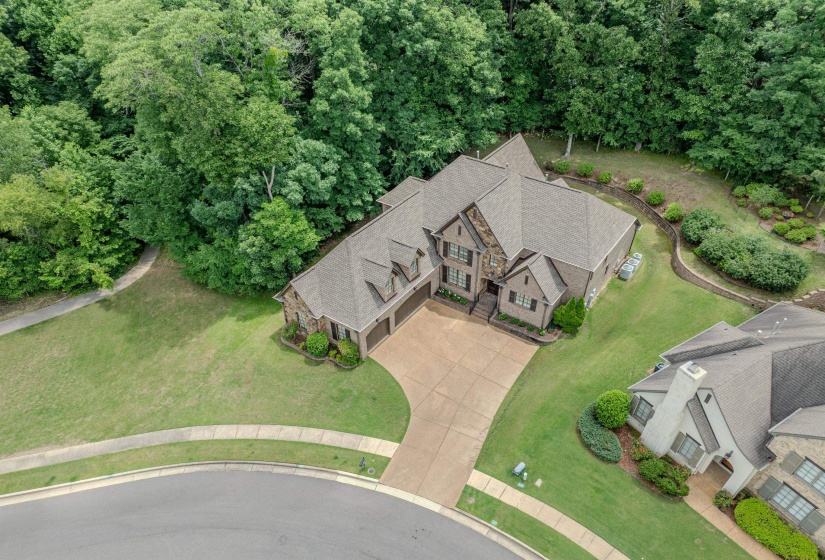 Traditional-style home featuring a stone and brick exterior, a multi-car garage, and a gabled roofline