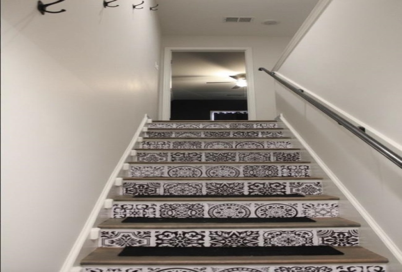 Staircase featuring wood-finish treads and risers with decorative patterned tile accents