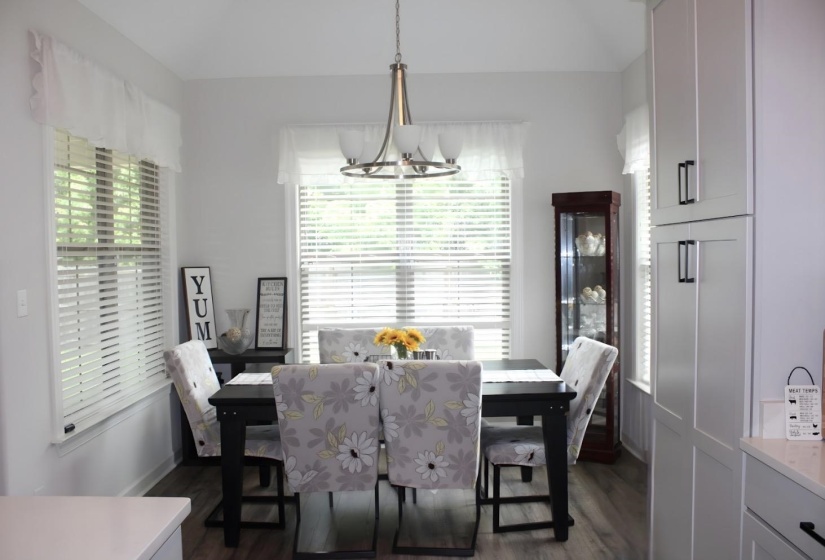 Dining area featuring wood-finish flooring, two large windows with blinds, and recessed lighting