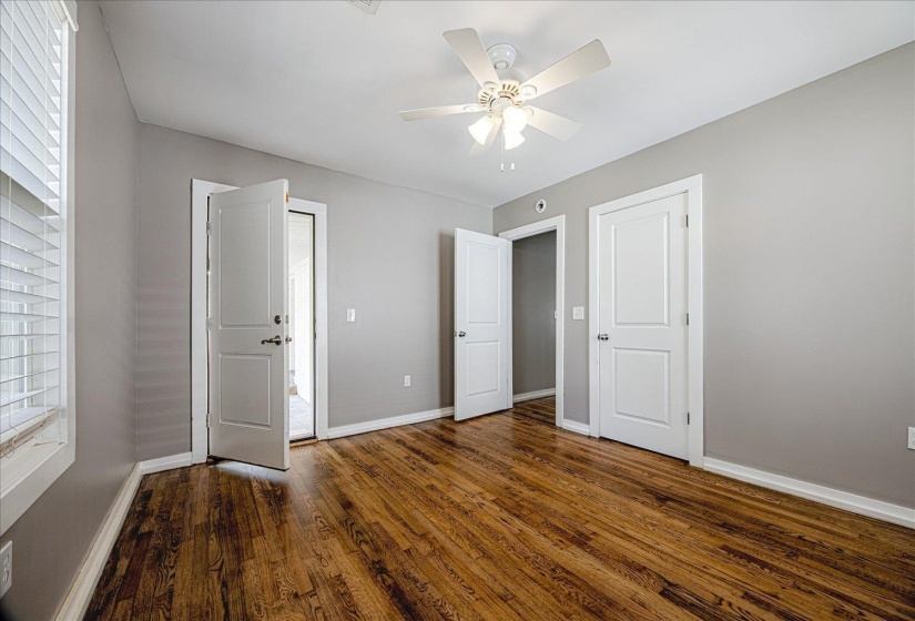 Unfurnished bedroom with dark wood-style flooring and ceiling fan