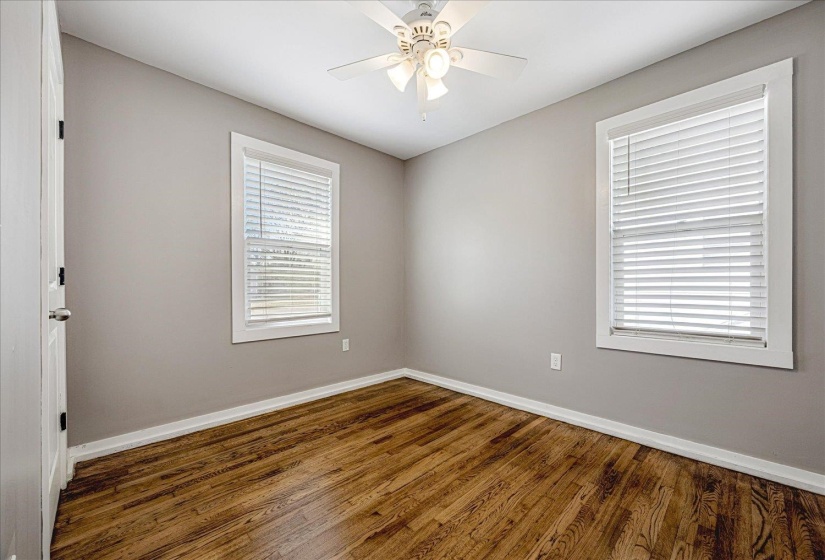 Unfurnished room featuring dark wood finished floors and ceiling fan