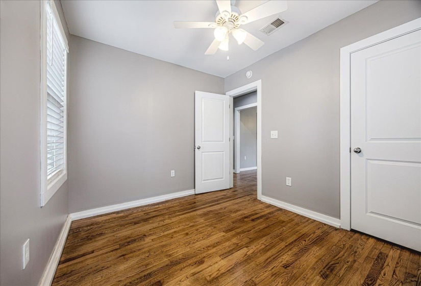 Unfurnished bedroom with dark wood-style floors and a ceiling fan