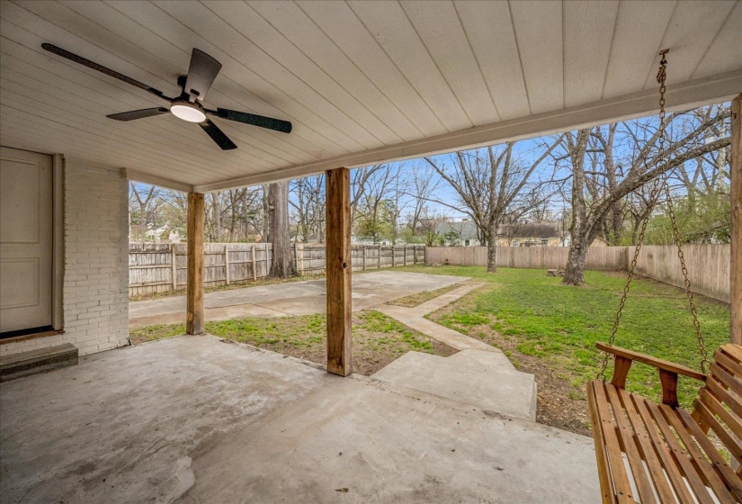 Fenced backyard with a patio and ceiling fan