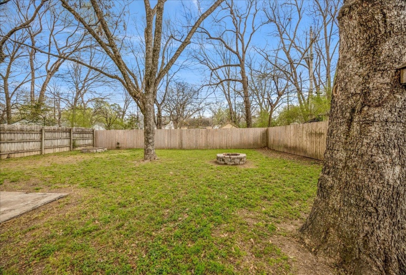 Fenced backyard featuring a fire pit