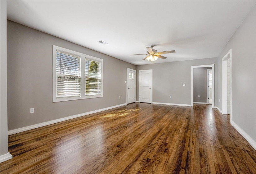 Unfurnished living room with ceiling fan and dark wood-style floors