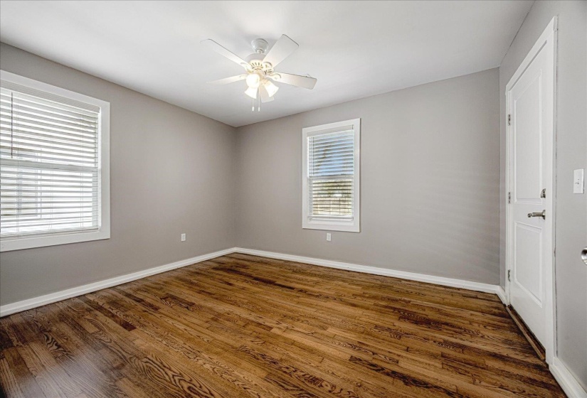 Spare room featuring dark wood-style flooring and a ceiling fan