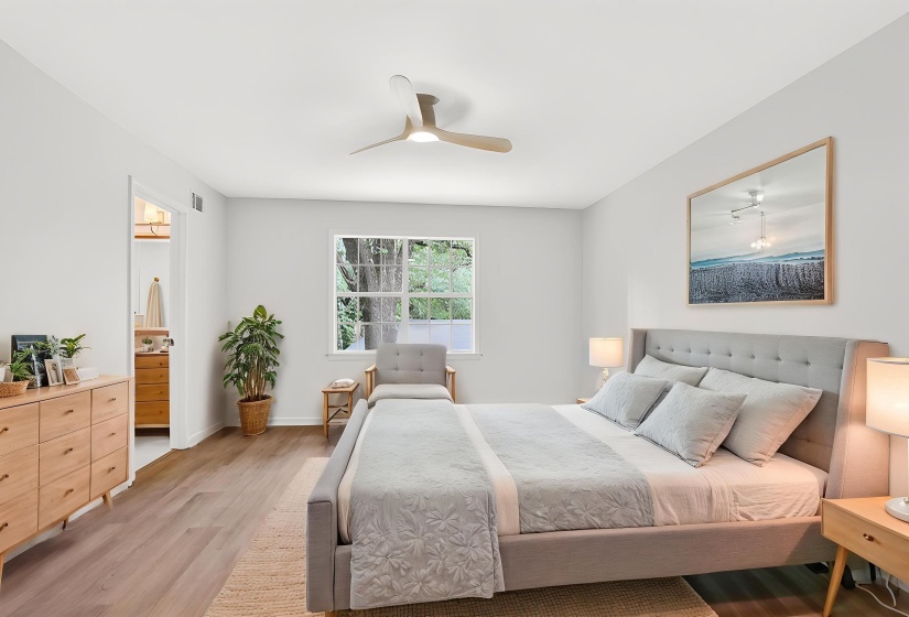 Spacious interior featuring wood-finish flooring, a contemporary ceiling fan, and a large window
