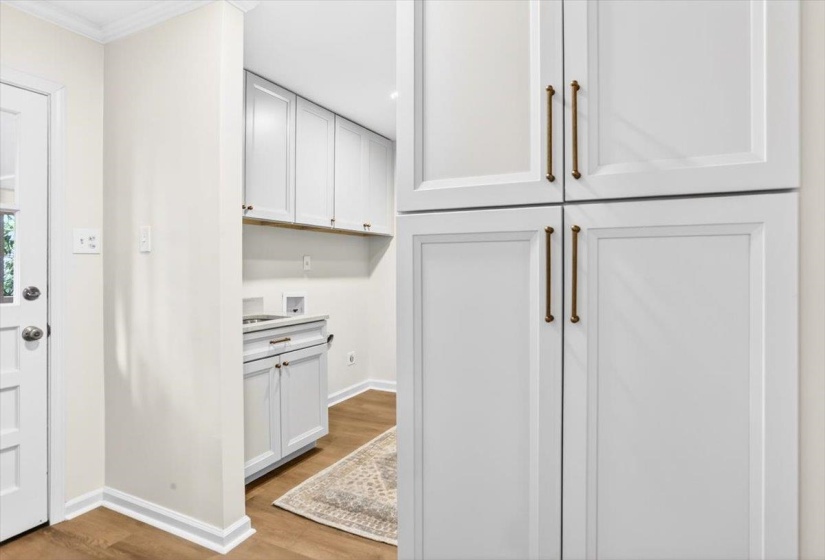 Tall white paneled cabinetry with brass hardware