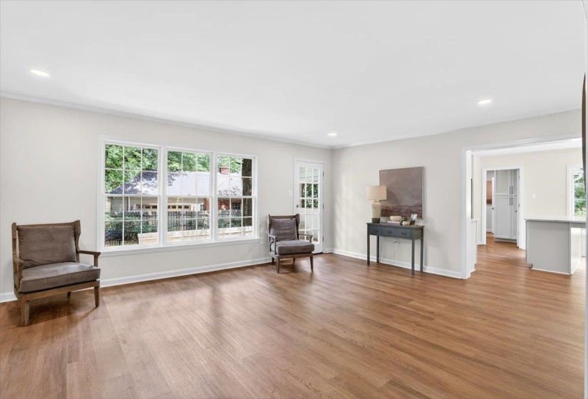 Open living space featuring wood-finish flooring and recessed lighting
