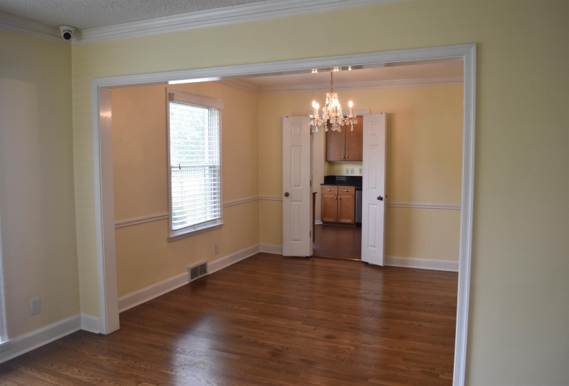Hardwood-finish flooring throughout, featuring an open doorway to an additional room with bi-fold doors