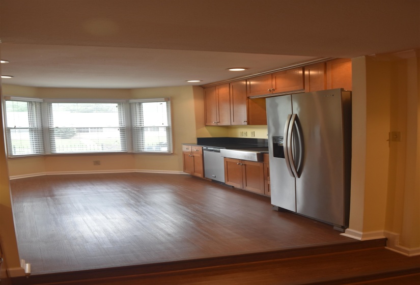 Kitchen area featuring wood-finish flooring, recessed lighting, and a bay window