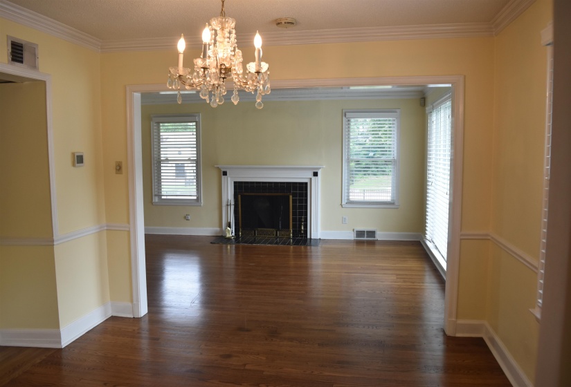 Spacious interior offering hardwood flooring, white baseboards, and crown molding