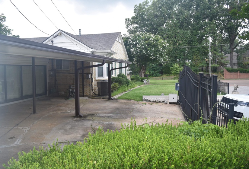 Brick exterior featuring a covered carport, bay window, and gabled roofline