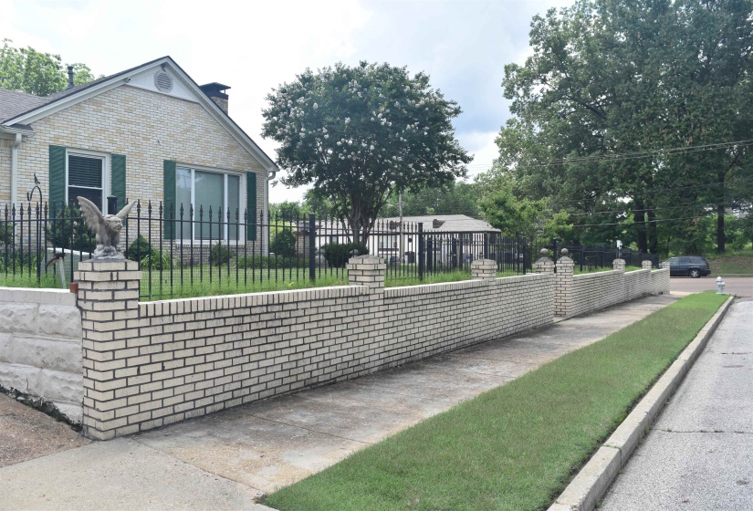 Traditional brick residence featuring a white brick exterior and dark green shutters