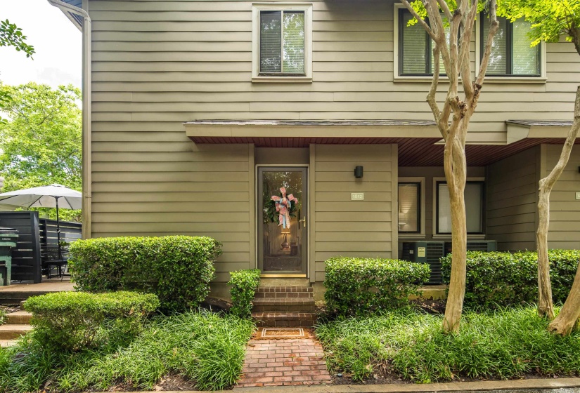 Front entry featuring a brick pathway and steps, surrounded by mature landscaping