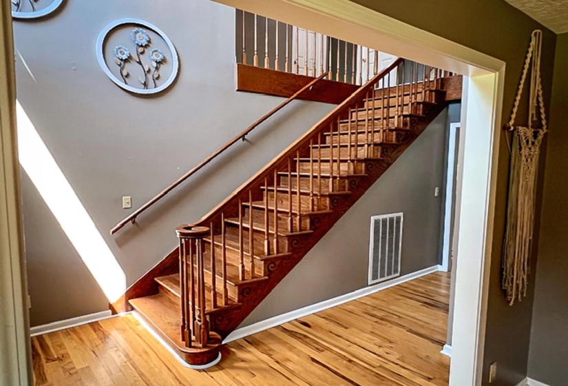 Staircase featuring wood treads, banister, and balusters