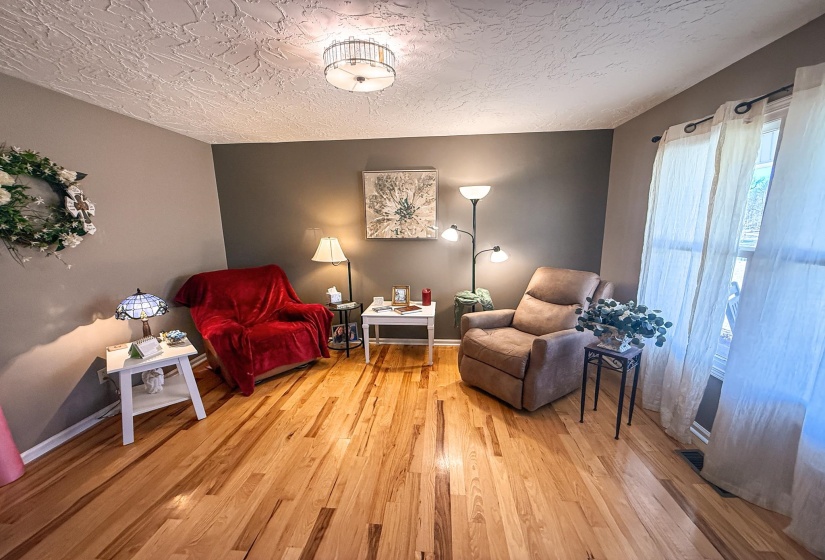 Lustrous wood-finish flooring complements the neutral wall color in this room