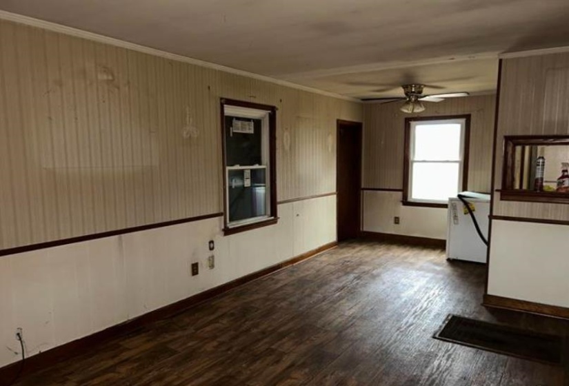Spacious interior featuring wood-finish flooring, two windows, and a ceiling fan