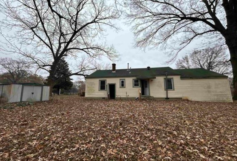 Single-story exterior with horizontal siding and a green shingle roof
