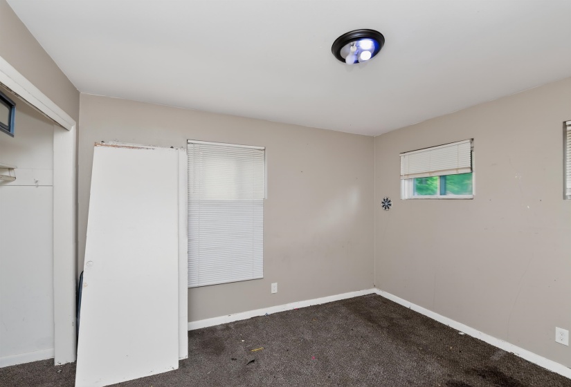 Room featuring neutral painted walls, dark carpeting, and a ceiling-mounted light fixture