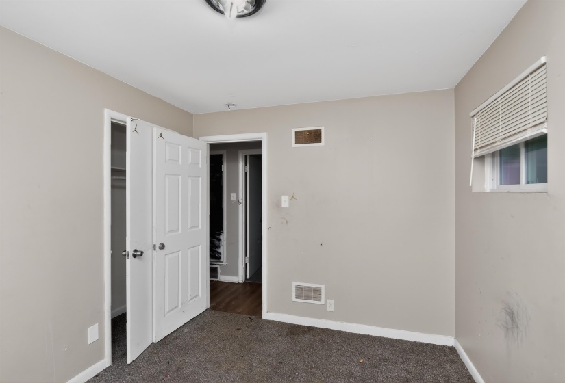 Carpeted room featuring neutral wall paint, white trim, and a window with horizontal blinds