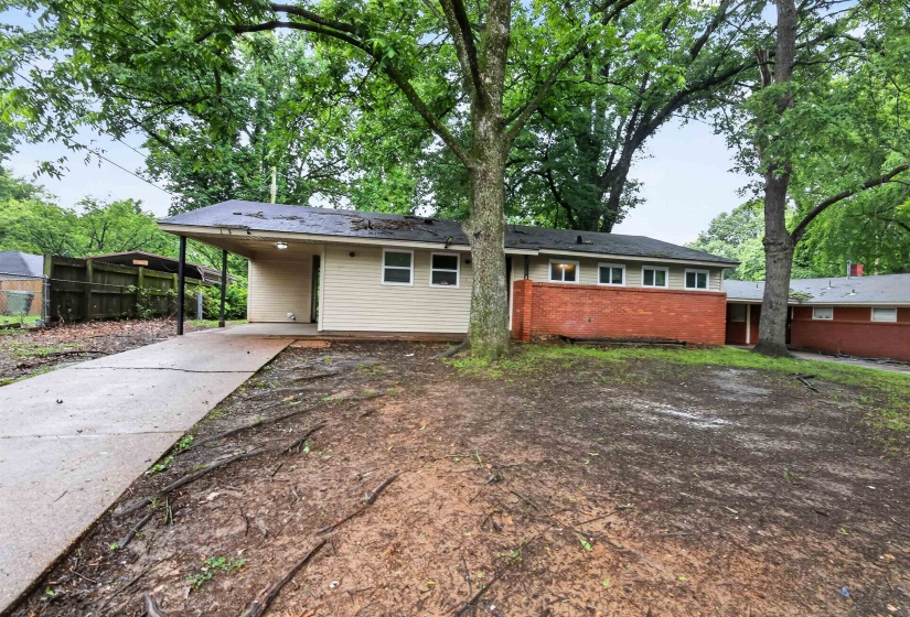 Ranch-style exterior featuring a carport, horizontal siding, and a red brick facade