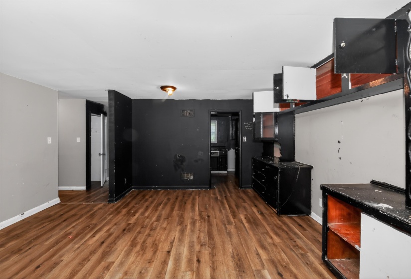 Wood-finish flooring throughout, featuring a built-in cabinetry unit with display shelves and upper storage
