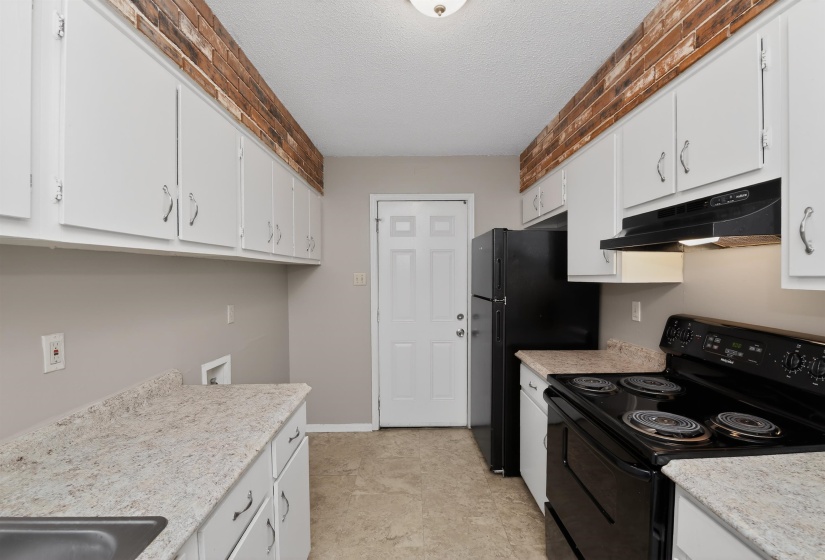 Kitchen featuring white cabinetry and light-toned countertops